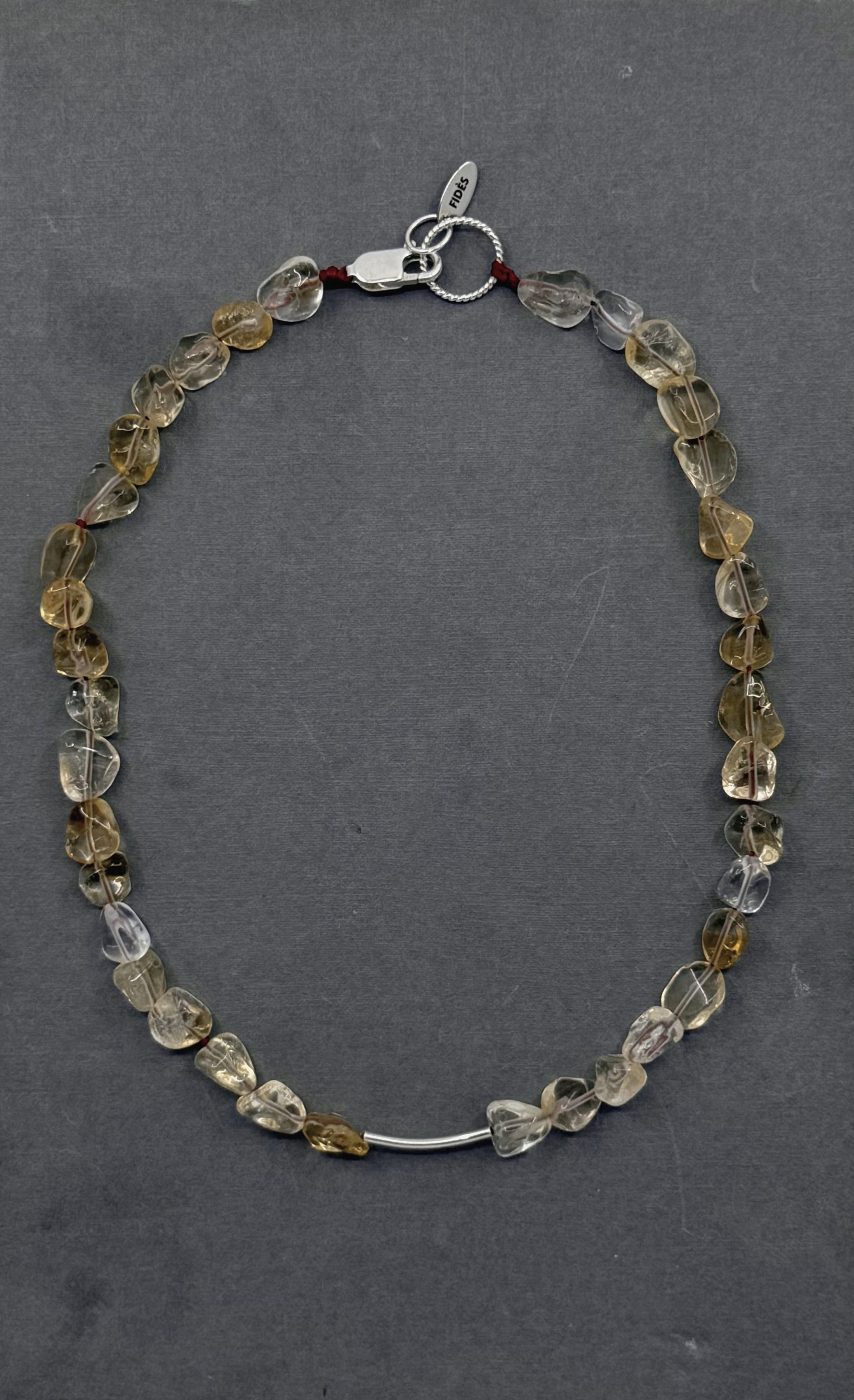 Necklace with multicolored beads on a gray book